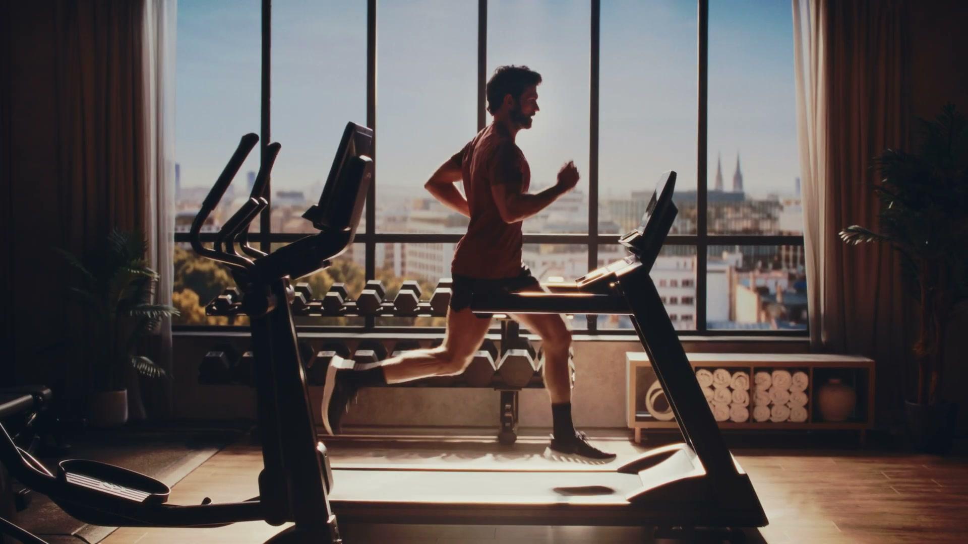Life Fitness Atmos treadmill side-on running shot with full window backplate