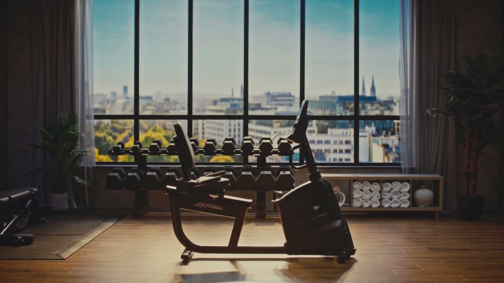 Life Fitness Atmos recumbent bike establishing shot inside the hotel-gym set