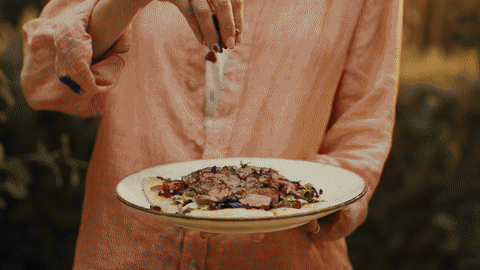 Hand squeezing a lemon over grilled prawns, juice droplets frozen mid-air on the Kasai Konro grill.