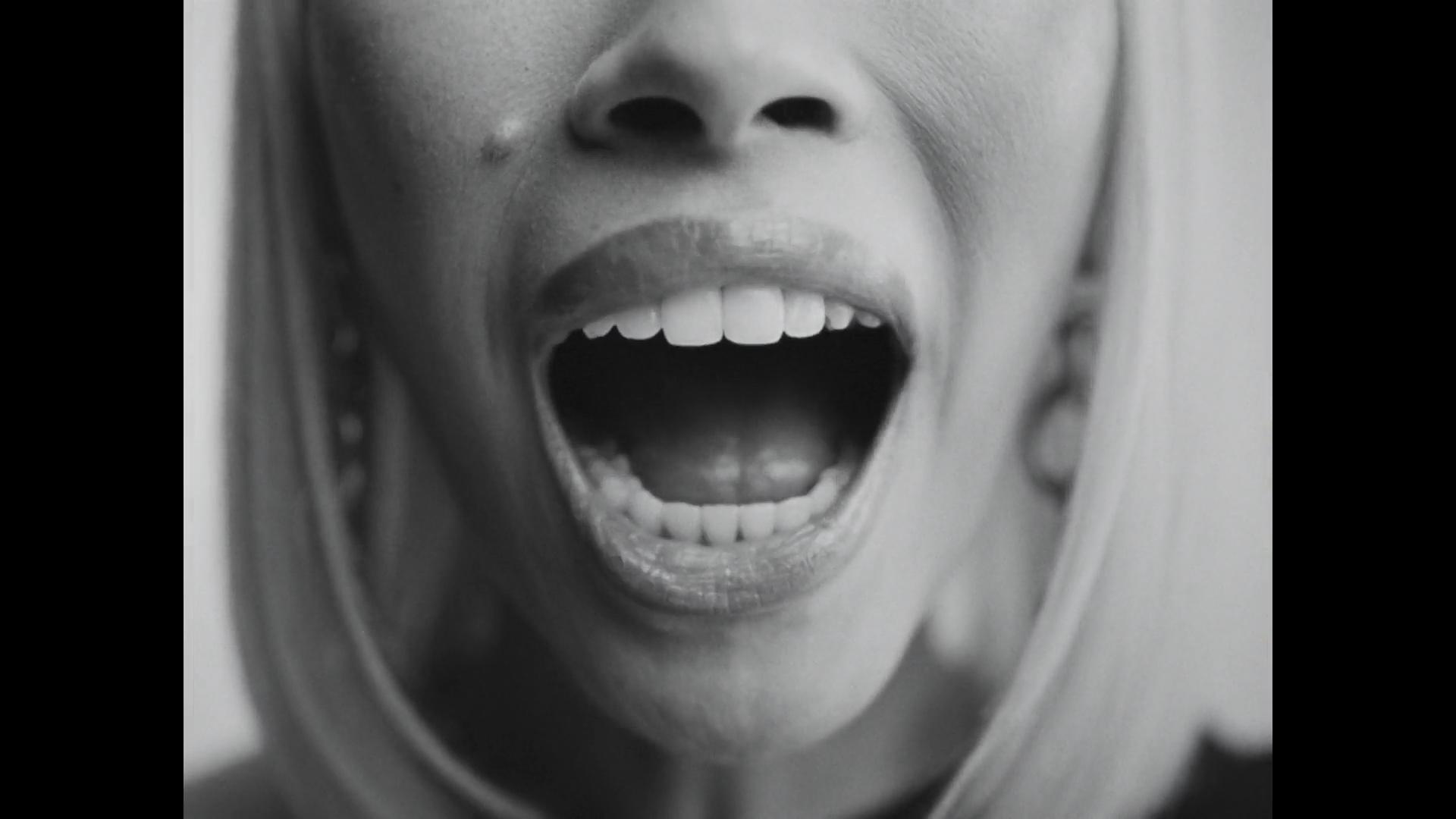 B&W extreme close-up of models pursed lips and lower face.
