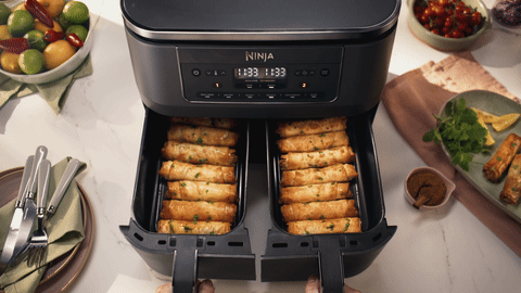 Top-down hero of the Ninja DZ300 with both drawers open and filled with golden filo rolls, control panel reading 11:33 with MATCH selected.