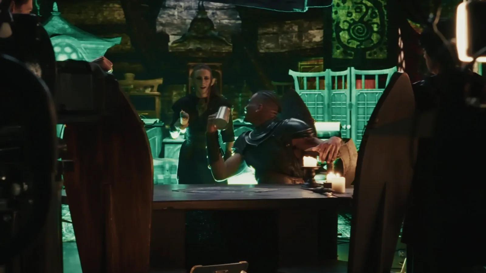 Dark-elf alchemist serves a tankard to an armoured warrior in a tavern scene.